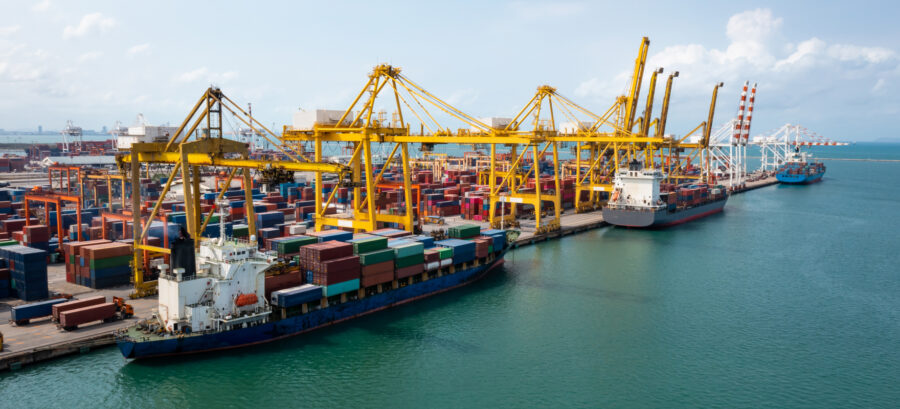 Container terminal with stacked containers, quay cranes and vessels at berth